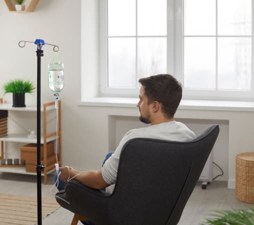 A Man Seated With An Iv Drip, Indicating Medical Care