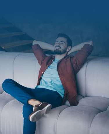 A Man Relaxing On A Couch In A Cozy Living Room
