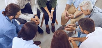 A Diverse Group Of Individuals Seated In A Circle, Engaged In Discussion