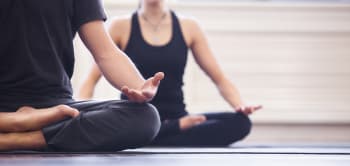 A Man And Woman Sit In A Yoga Pose, Showcasing Balance And Tranquility Indoors