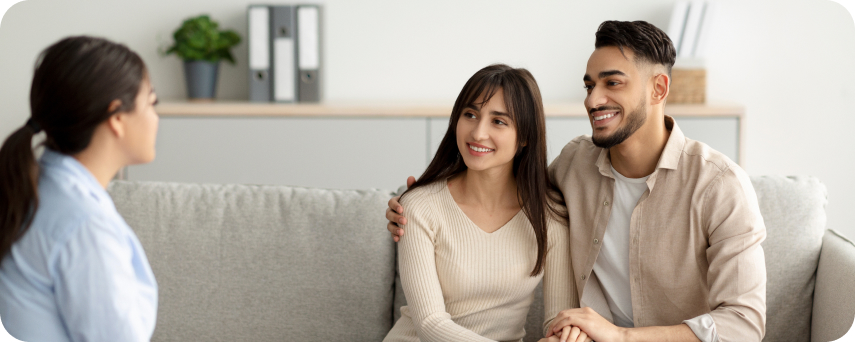 A Man Converses With A Couple On A Couch, Fostering A Friendly Atmosphere
