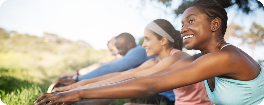 A Diverse Group Stretching On Green Grass In The Sun