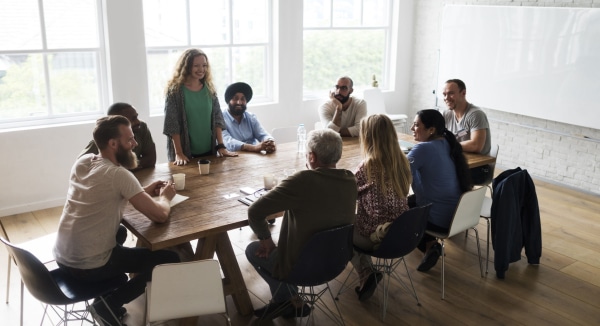 A Team Focused On Discussion At A Table In An Office Setting