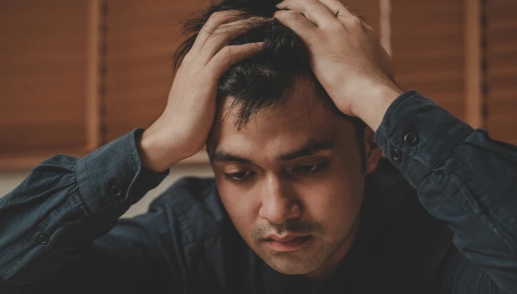A Sad Young Man Holding His Head.